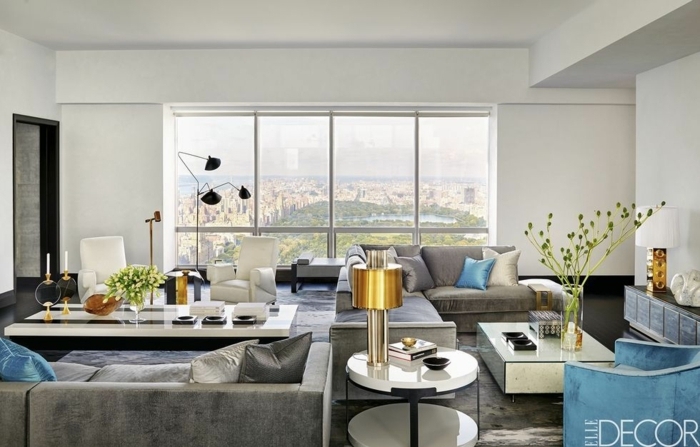 salon de encanto con grandes ventanales con vista, sofá en gris y sillón tapizado de terciopelo en azul 