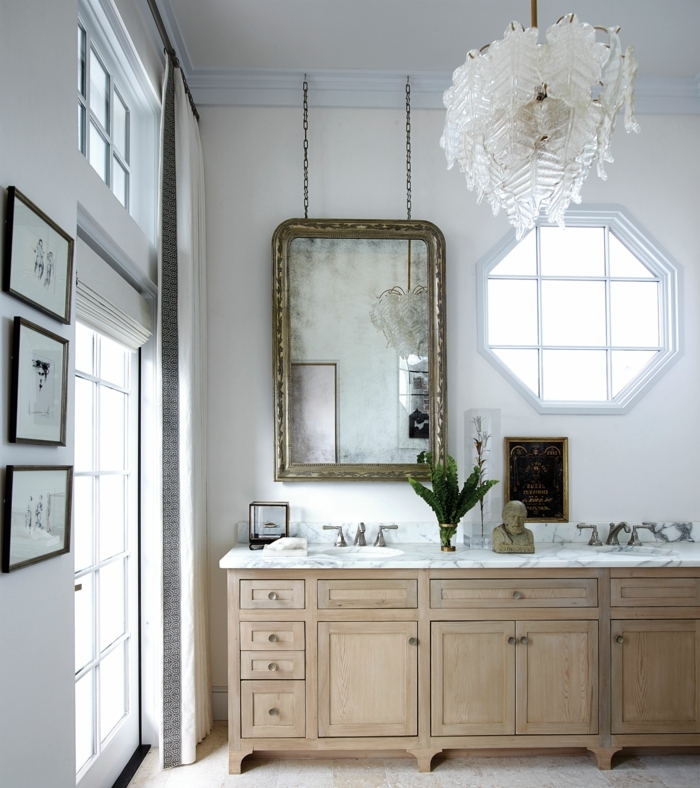 como decorar la casa con espejos vintage, grande espejo con marco dorado colgado en la pared, lámpara de araña en blanco 