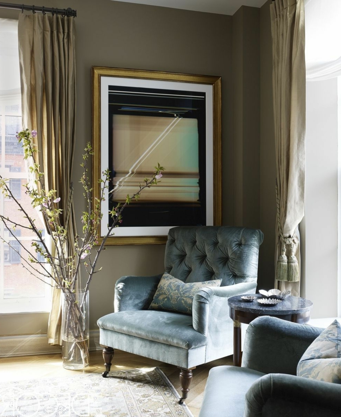 bonita combinación de ocre y gris, sillones elegantes tapizados en capitoné, decoracion salon moderno con paredes en beige y cortinas en dorado 