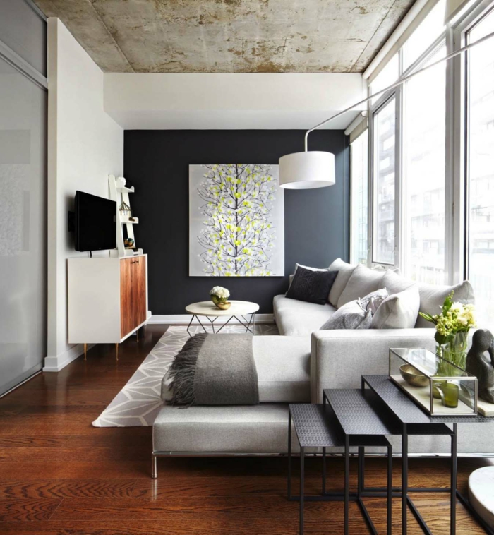 salon moderno con grande sofa decorado en beige y paredes en blanco y negro, bonita pintura en la pared 