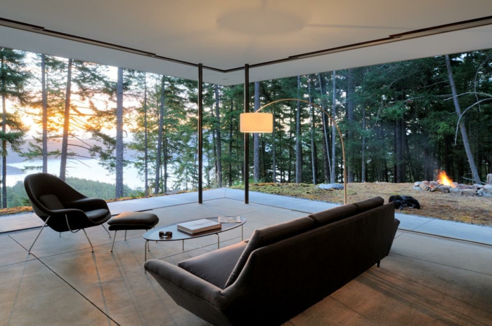 precioso interior con grandes ventanales y vista, sofá en color marrón tapizado de piel, suelo en beige 