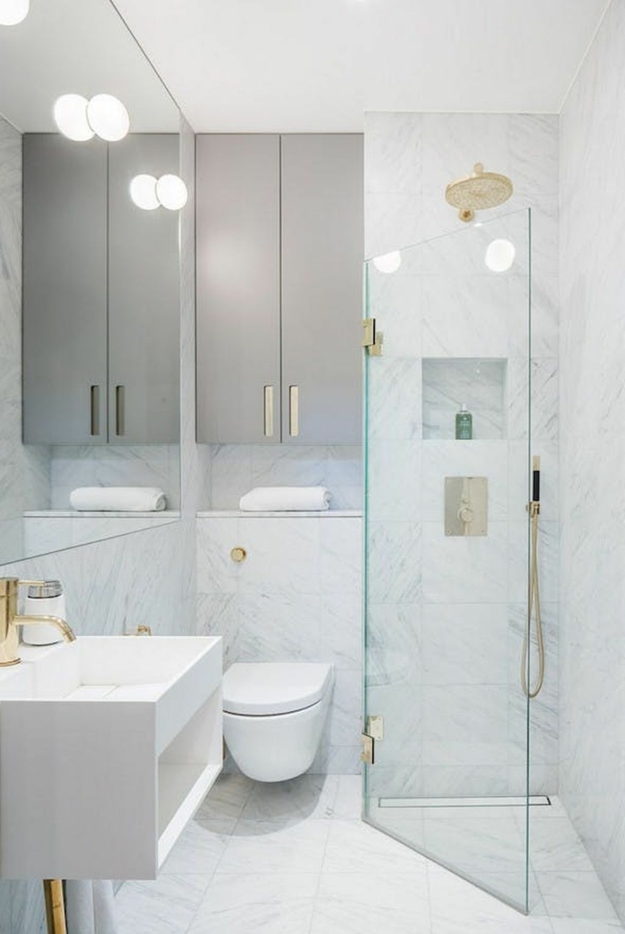 baño pequeño con mampara de ducha plegable, decoracion en blanco con marmol, decoracion baños pequeños, espejo grande, lavabo rectangular