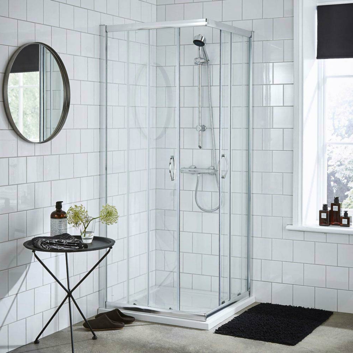 baño moderno con cabina de ducha en el angulo, ventana grande, cuartos de baño, espejo redondo, mesita redonda negra