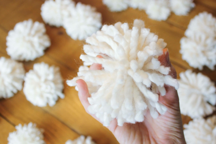 como hacer pompones pequeños y grandes, tutorial paso a paso, bolas de lana blanca para decorar la casa en Navidad 