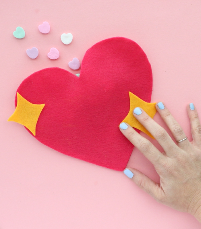 manualidades de fieltro para el día de san valentín, bolsa DIY en forma de corazón llena de caramelos en colores pastel 