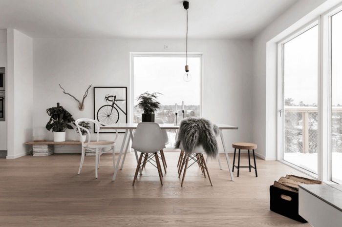 salon nordico, comedor minimalista, sillas blancas, cuadro con bicicleta, bombilla colgante, ventanales, terraza en nvierno