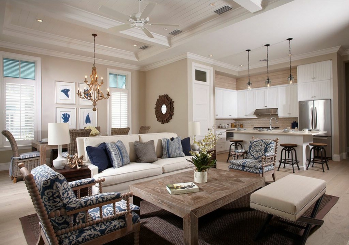 espacio moderno en colores claros con detalles en estampados, tapizado de sillón con motivos florales, cocina abierta en blanco y beige 