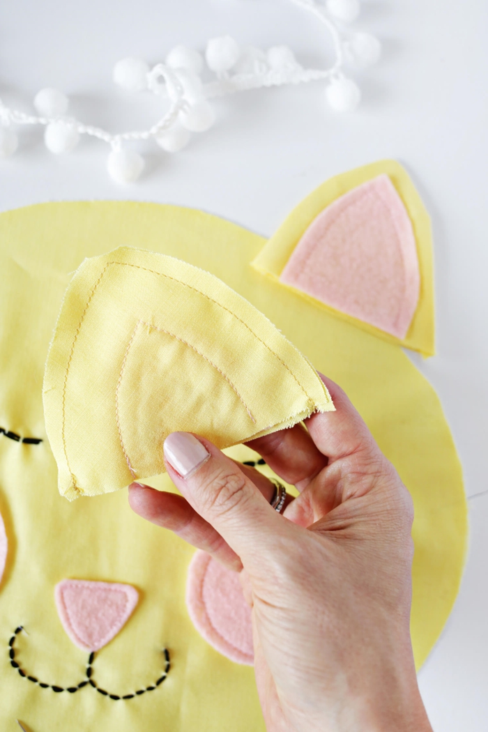 como cocer las orejas de un gato decorativo, almohadas DIY hechas de tela de algodón en amarillo y rosado, manualidades con tela ideas divertidas