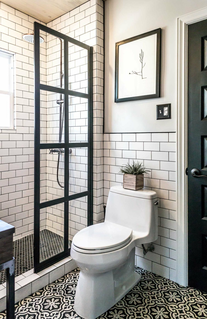 ducha de obra con mampara de vidrio en marco negro, decoracion moderna, cuadro sobre el vñater, ventana pequeña, baños pequeños con ducha
