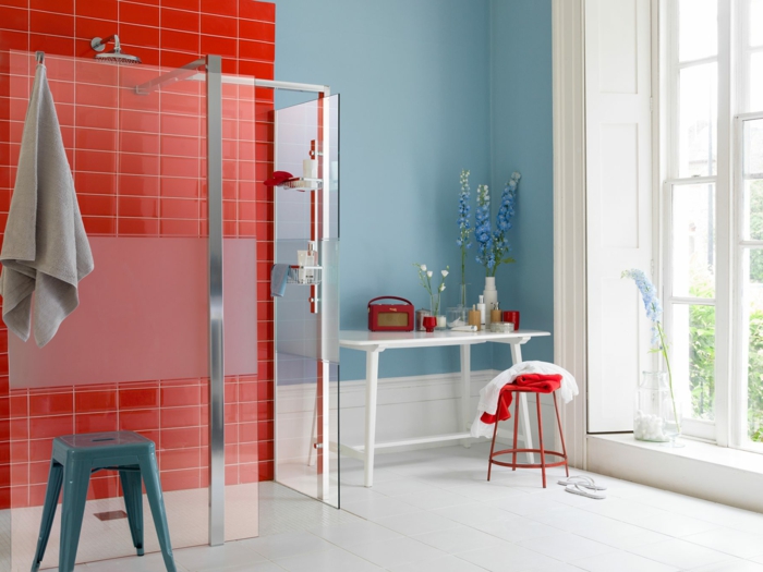 baño pequeño moderno con mucha luz natural, pared en azul, mesa de madera blanca, baldosas rojas, cuartos de baño pequeños, ducha de obra, mampara de vidrio
