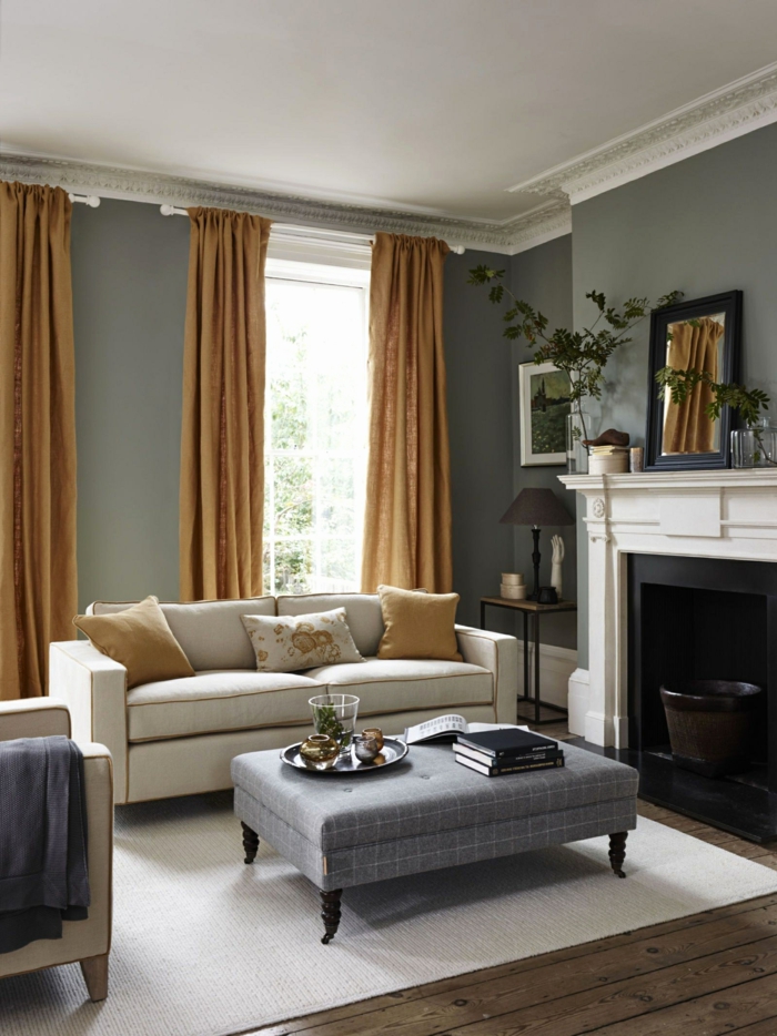 habitación gris, decoración salon en gris, beige y color cognac, chimenea, suelo de tarima, taburete como mesa, techo con moldura