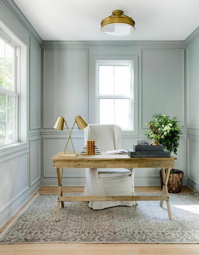 despacho pequeño con escritorio de amdera y sillon tapizado, paredes grises con moldura, luz natural, alfombra, planta verde, como decorar una habitacion