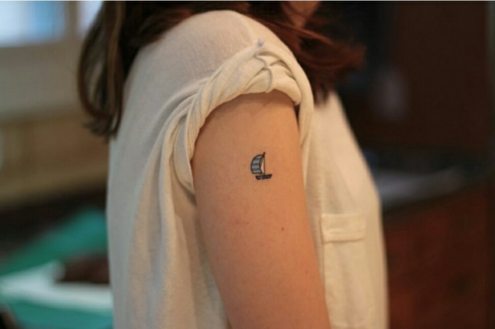 tatuajes con significado, diseño tatuaje de brazo para mujer, barco velero en blanco y azul, blusa blanca con mangas cortas