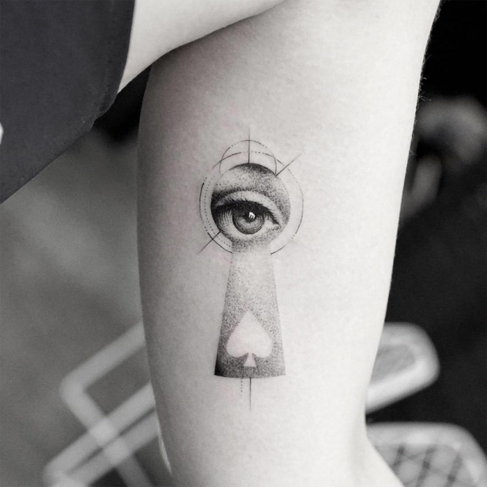 foto en blanco y negro, tatuaje surrealista con llave y ojo, tatuajes originales, diseño para brazo de mujer