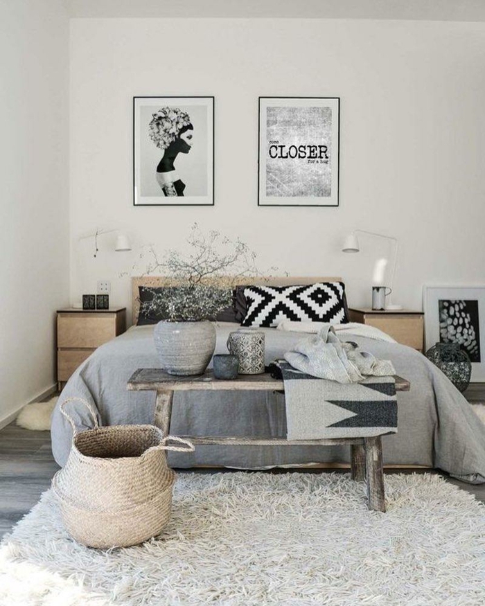 decoracion moderna estilo escandinavo, habitacion gris y blanca, cama matrimonio, posteres en blanco y negro, tapete peludo, banco de madera