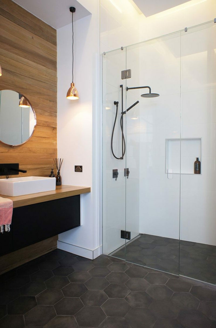 decoración minimalista, baños modernos, pared de acento con listones de madera, suelo con baldosas hexagonales, espejo redondo, lámpara colgante, ducha de obra con mámpara de vidrio