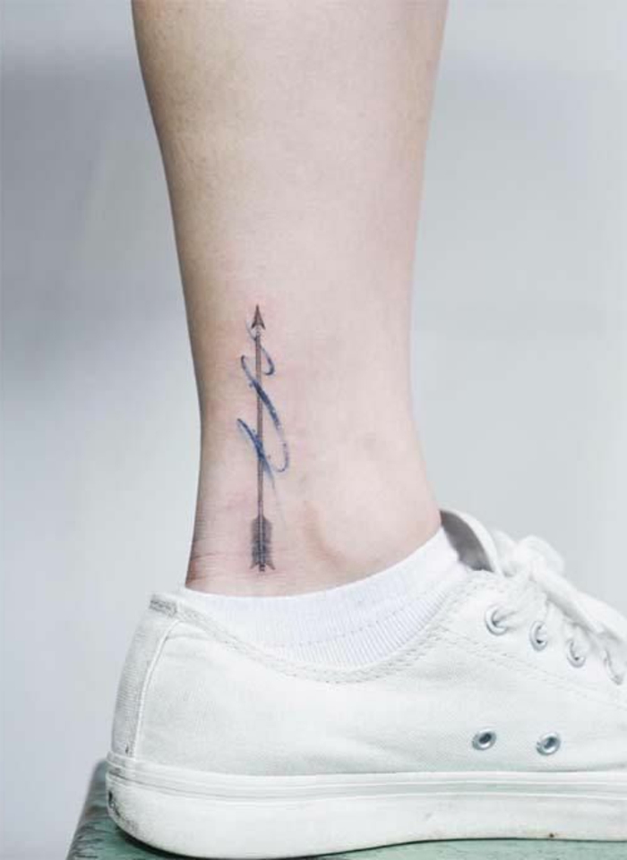 flecha en movimiento, azul y negro, tatuaje en el tobillo, hombre con zapatillas blancas, tatuajes pequeños con significado