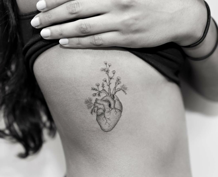 tatuajes originales, foto en blanco y negro, mujer con tattoo en el torso, flores que crecen en corazon anatomico