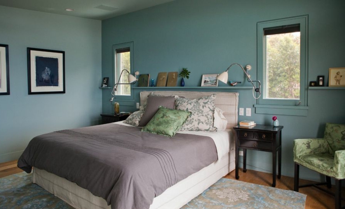 dormitorio acogedor con ventanas pequeñas, paredes en azul grisáceo, alfombra grande, sillón y cuadros, habitacion gris y blanca