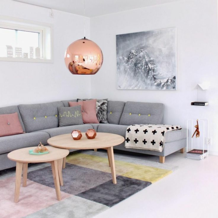 salon nordico, gris combinado con blanco y rosado, mesas redondas de madera clara, alfombra en cuadros de color, lampara cobriza, como decorar una habitacion