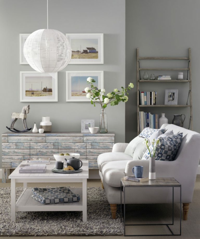 decoracion en gris y azul, mueble auxiliar pintado a la tiza, sofá con cojines, habitacion gris, flores blancas, tapete y mesa de madera