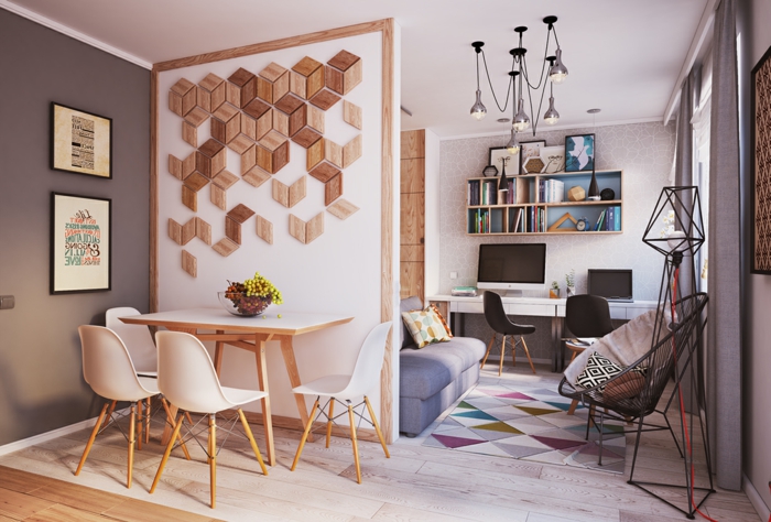 salon comedor pequeño, decoracion nordica salon, pared decorada con pedazos de madera, mesa y sillas de plástico y madera clara, tapete con triángulos, silla acapulco, escritorio y estantería pequeña