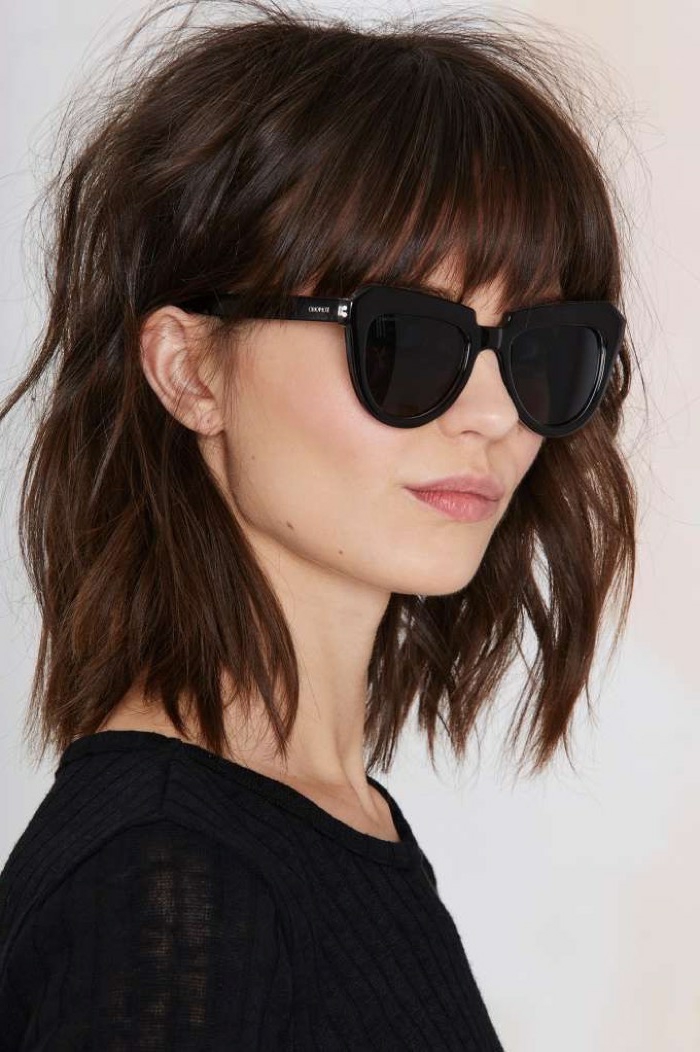 mujer de perfil con gafas de sol negras, media melena con flequillo largo depuntado, cortes de pelo media melena