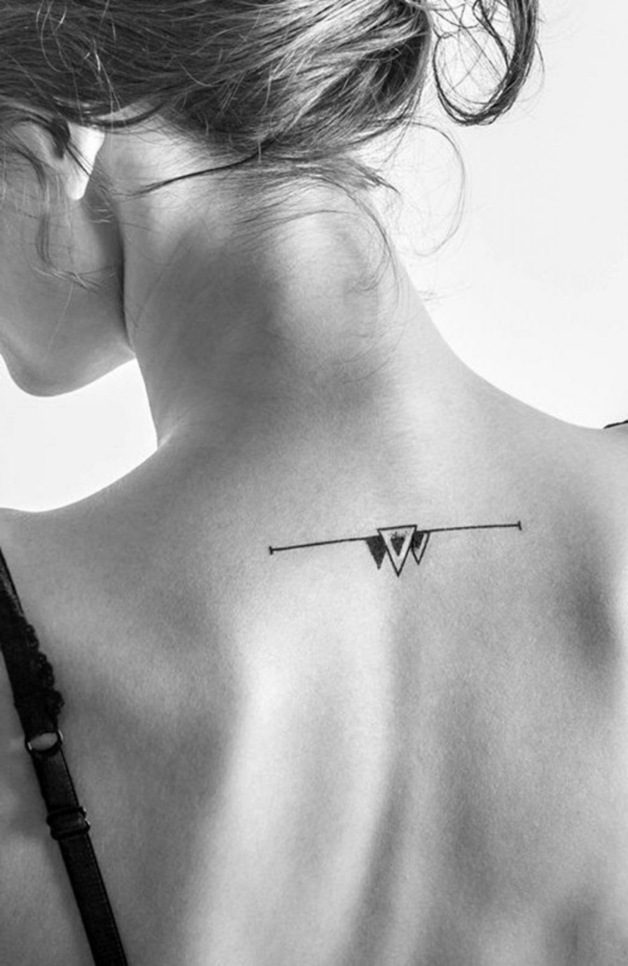 mujer con pelo largo recogido, tatuaje geometrico en la espalda, linea recta con triángulos, blanco y negro, tatuajes minimalistas