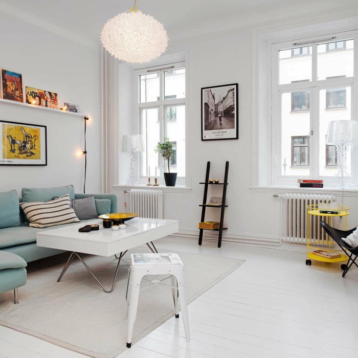 decoracion estilo nordico, salón con mesa blanca laminada, sofá en color aguamarina, bombillas y escalera decorativas, mesita amarilla de ruedas
