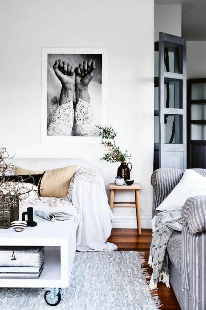salon en blanco y gris, estilo nordico, sofás con cojines, mesita de ruedas, fotografia de brazos femeninos en blanco y negro, flores secas