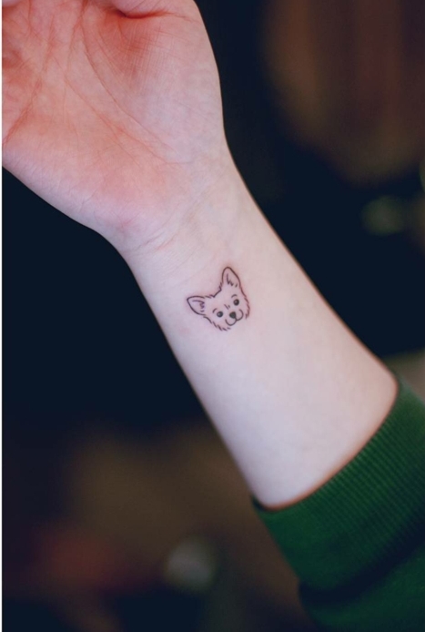 idea de tatuaje para mujeres, mano con manga verde, cara de perrito pequeño, tatuaje minimalista, tatuajes flechas