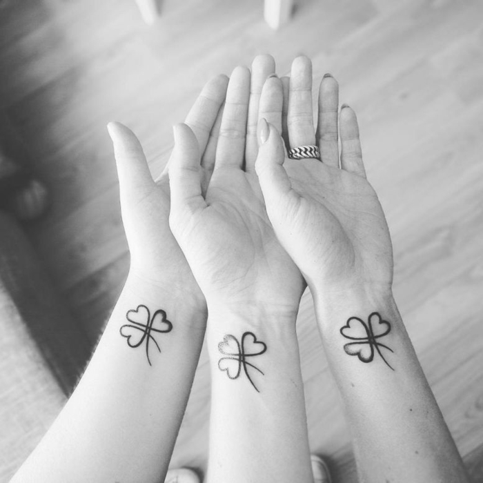 foto en blanco y negro, tatuajes iguales para hermanas, simbolos que signifiquen familia, tatuaje trébol en la muñeca