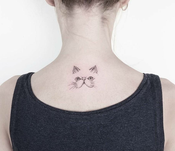 mujer con pelo recogido, tatuaje en la espalda, blusa negra, tatuajes elegantes, cara de gato