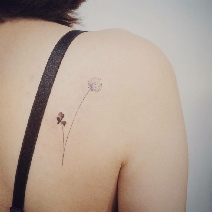 mujer con tatuaje en la espalda, trebol y diente de leon, tatuajes pequeños mujer, idea tattoo delicado