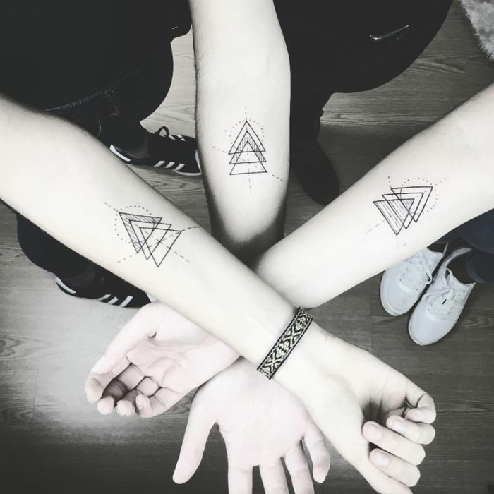 tatuaje geométrico en el antebrazo, tatuajes iguales para hermanos. simbolo de familia, tres triángulos entrelazados