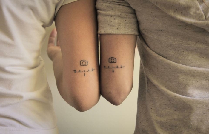 tatuajes minimalistas para fotógrafos apasionados, tatuajes para hermanas, tattoo en el antebrazo, cámara fotográfica y números
