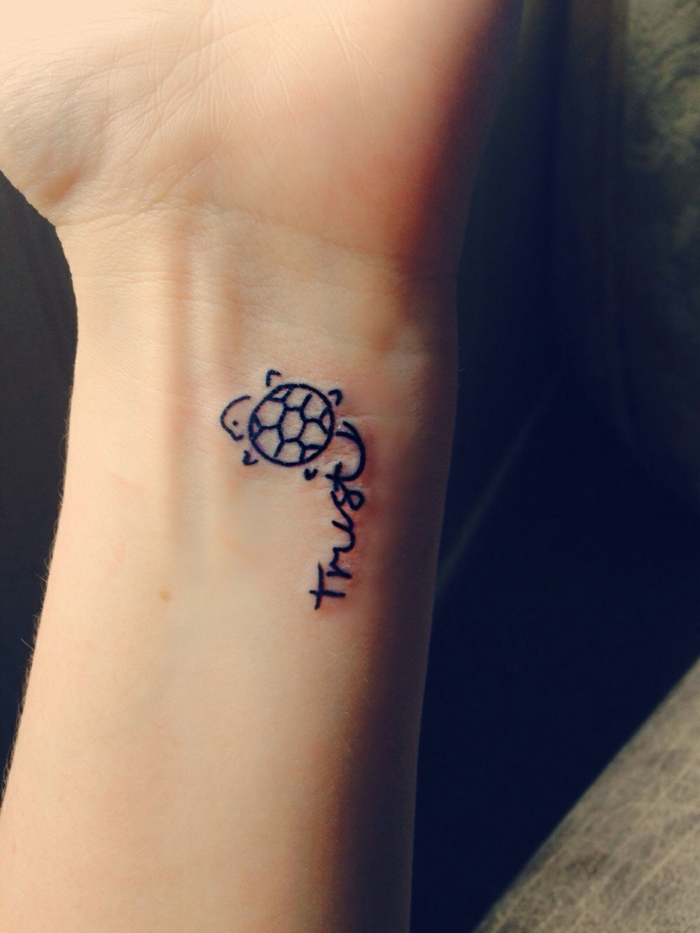 mini tatuaje con imágen y palabra, tortuga estilo dibujo infantil, tatuajes de nombres en la muñeca, mano de mujer