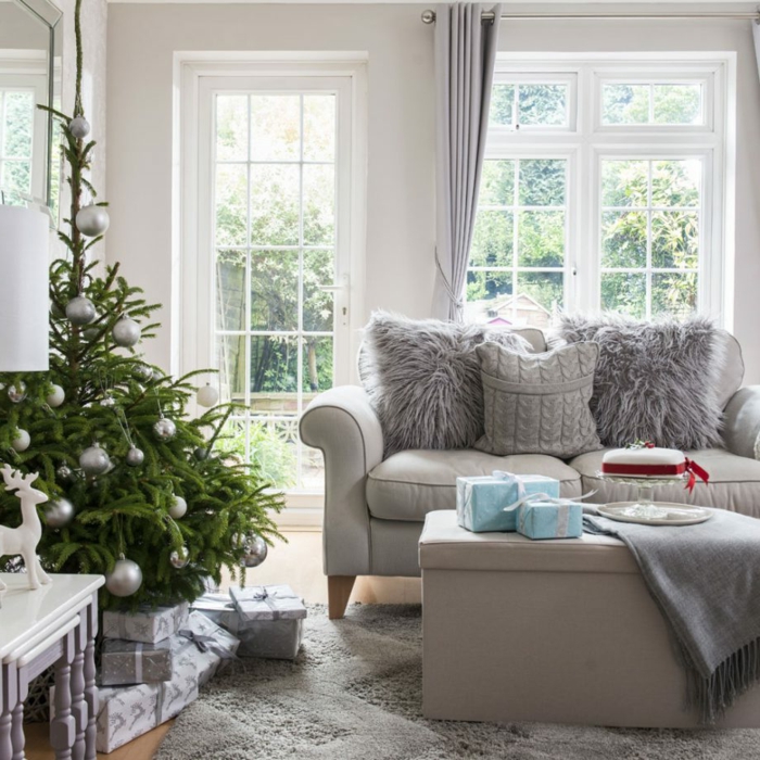 bonita decoracion de salones en gris, sofá y mesa en gris, decoración navideña, grandes ventanales blancos con cortinas en gris