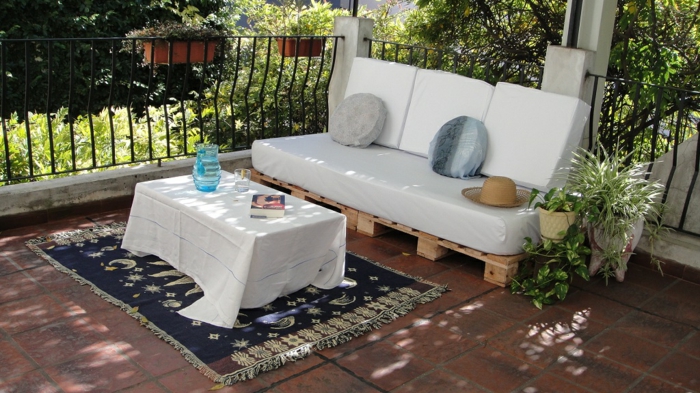ejemplos de muebles de palets de encanto, sofá en blanco con palets y colchonetas blancas, macetas con plantas verdes