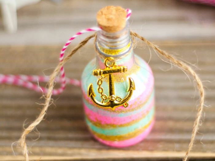 ideas encantadoras de manualidades con botellas de cristal, botellas de vidrio colorida decorada con purpurina y elemento dorado colgante 