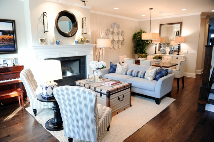 espacio decorado en estilo vintage, salon con sillones y sofa en azul celeste y blanco, suelo de parquet y y mesa de diseño original 