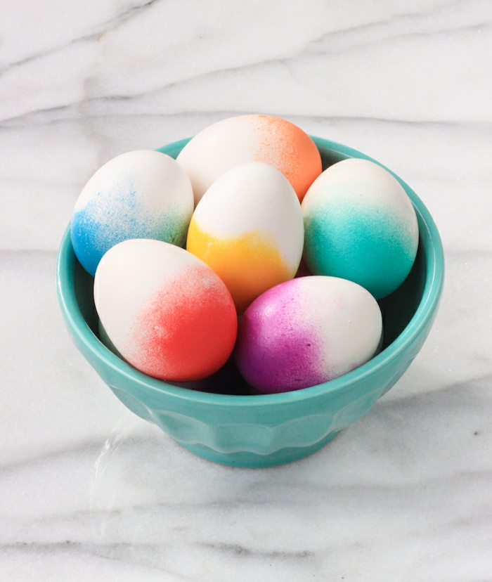 ideas de manualidades huevos de pascua, huevos decorados con spray en diferentes colores, huevos con efecto ombre