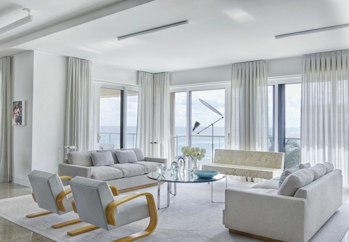 ejemplos decoracion salones modernos, precioso ambiente decorado en blanco y gris claro, sofás y sillones modernos y cortinas de lino 