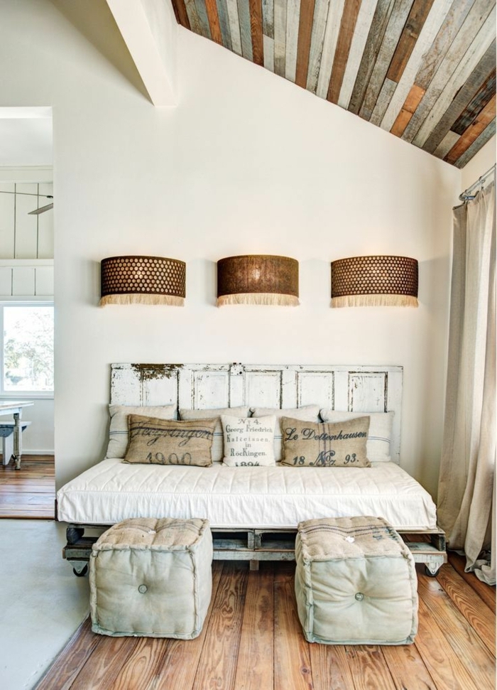 espacio en estilo vintage con techo inclinado, muebles hechos con palets y cama vintage con cabecero