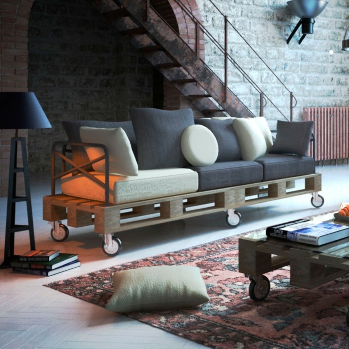 salón en estilo industrial con muebles hechos con palets, sofá en ruedas DIY y escaleras de hierro
