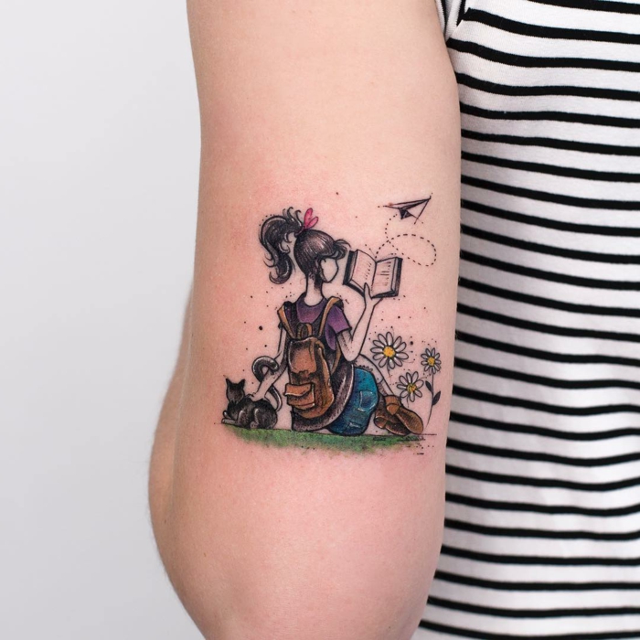 preciosos diseños de tatuajes en color, bonito dibujo de una niña leyendo con un gato, tendencias tatuajes 2018 