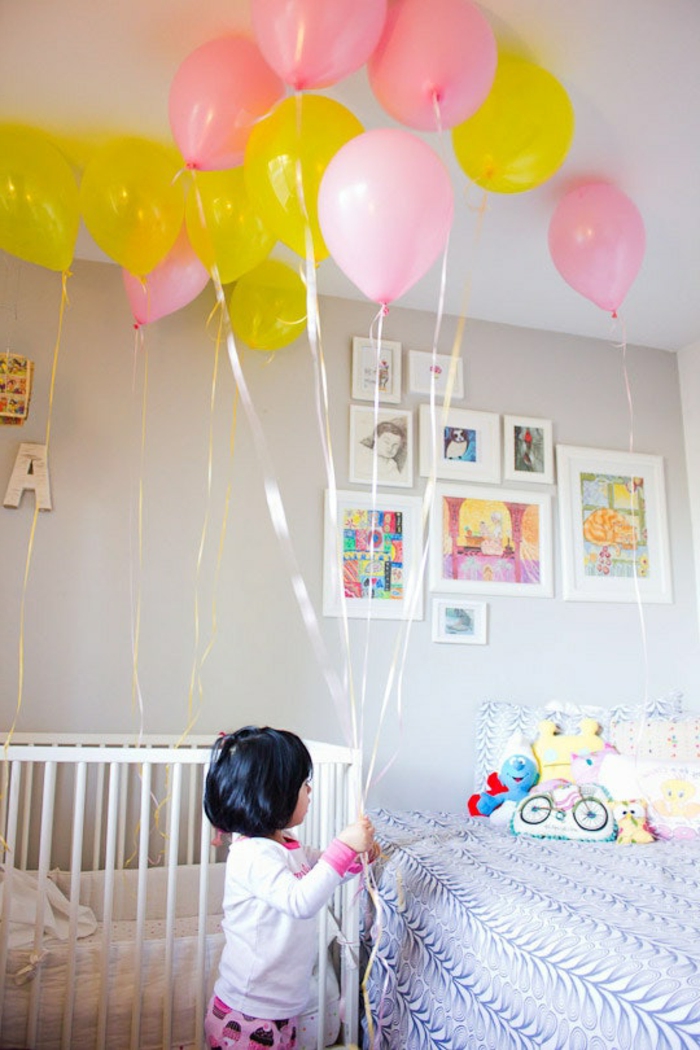 decoracion fiesta cumpleaños con globos en amarillo y rosado, dormitorio infantil decorado de manera encantadora 