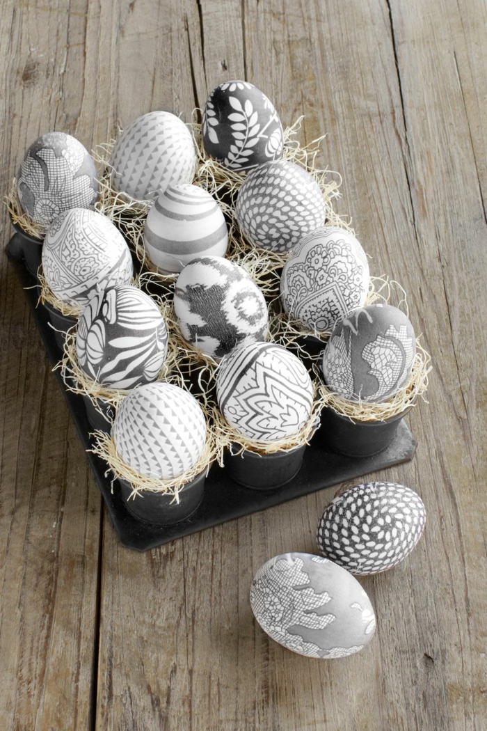 decoración sofisticada en gris, huevos de pascua para colorear blancos con bonitos dibujos con motivos florales y geométricos 
