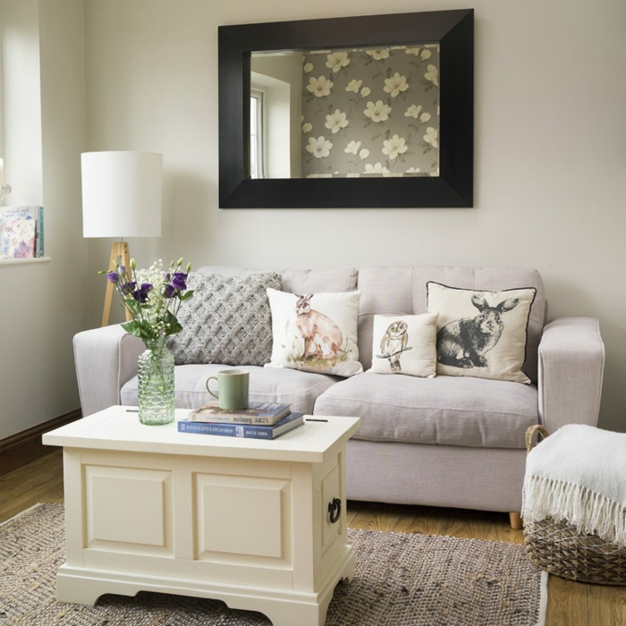 salon comedor moderno con bonita decoración, cojines decorativos originales y muebles en colores claros 
