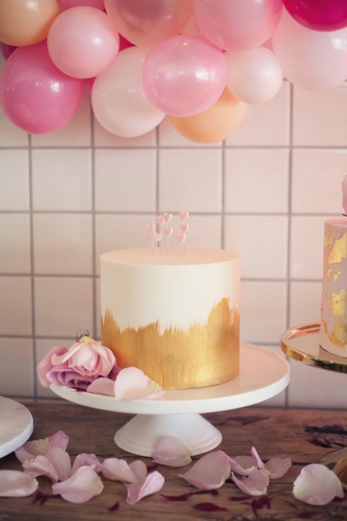 decoracion fiesta cumpleaños, preciosa idea de decoración con balones en rosado, tarta sofisticada y pétalos de rosas 